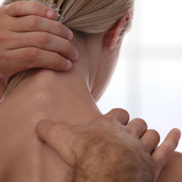 A man is giving a woman an acupressure treatment on her back.