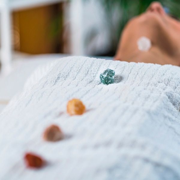 A person is lying on a towel with crystals on it getting a Chakra Energy HHealing Treatment