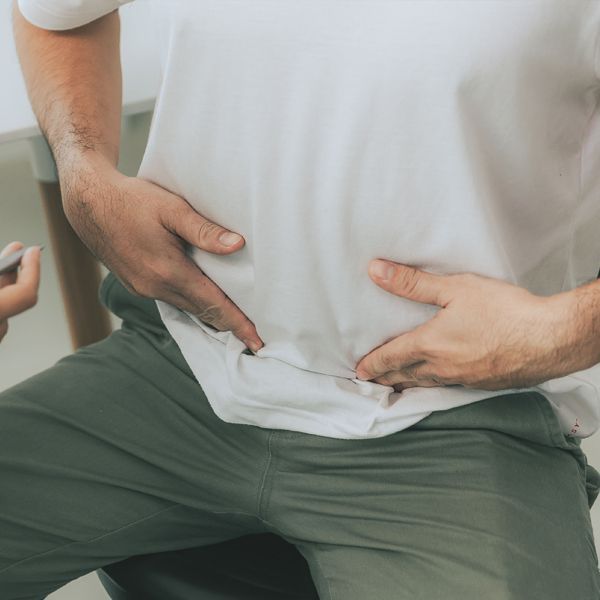 Man pointing to stomach pain from Crohn's Disease