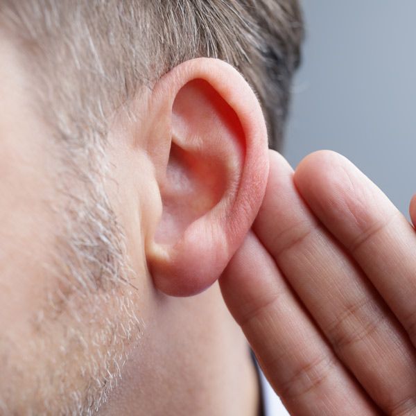 A man is covering his ear with his hand representing Frequency Adjustment of a Person's Name