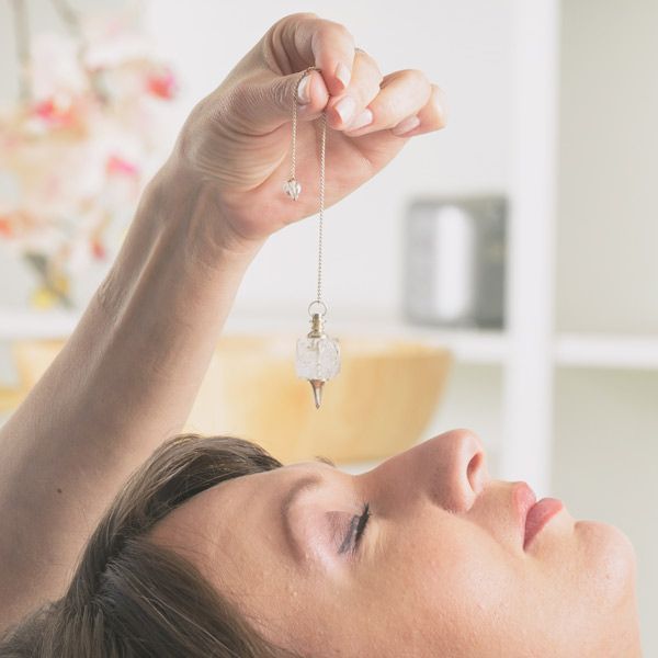 A woman is holding a pendulum over her head representing Pendulum Therapy