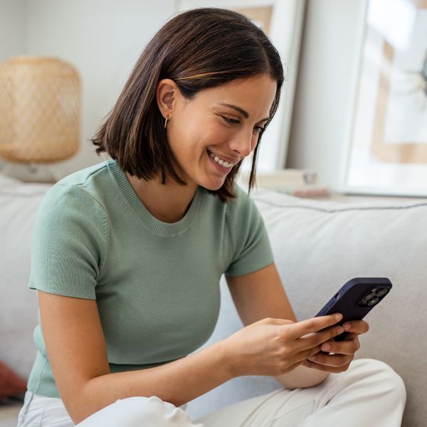 Woman on her cell phone Discovering More About Holistic Energy Bodyworks by reading Client Reviews