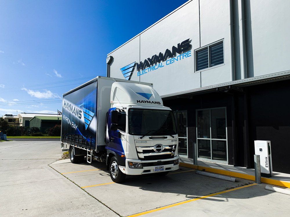 Haymans Electrical Centre Sign with Service Truck — Custom Signs in Byron Bay NSW