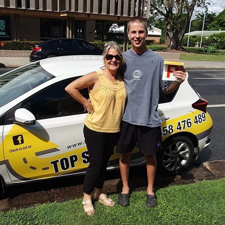 Standing in Front of a Car — Top Start Driving School In Cannonvale, QLD