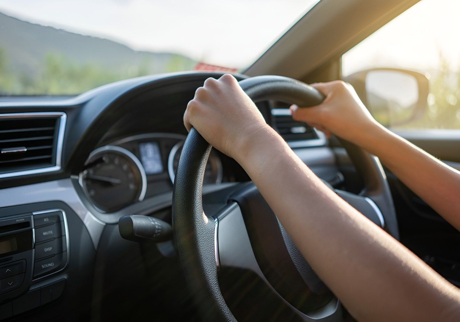 A Person is Driving a Car With Their Hands on the Steering Wheel — Top Start Driving School In Airlie Beach, QLD