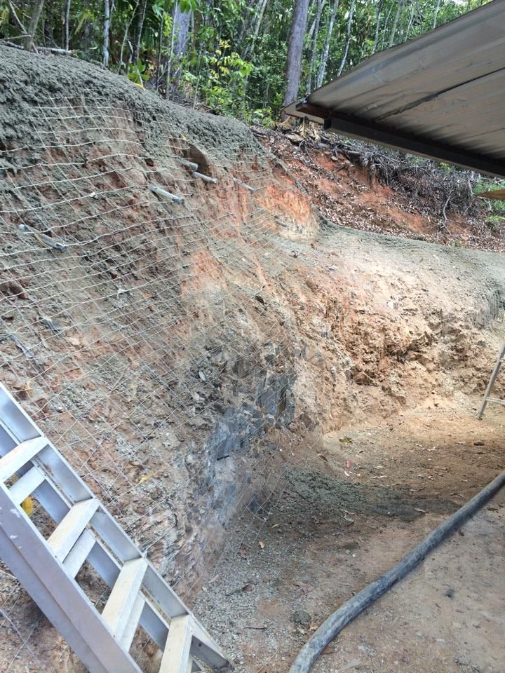 A Ladder is Sitting on Top of a Dirt Hill Next to a Hose — Far Northern Concrete Pumping in Cairns, QLD