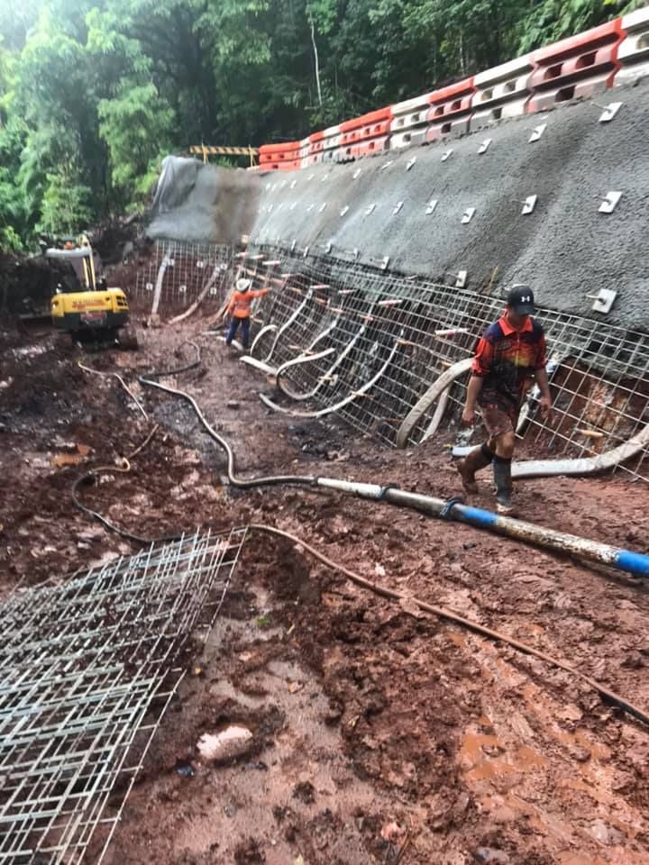 A Man is Standing in the Dirt in Front of a Concrete Wall — Far Northern Concrete Pumping in Cape York, QLD