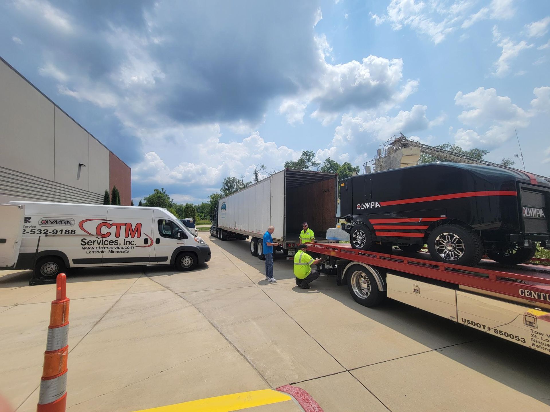 A car is being towed by a tow truck in a parking lot.