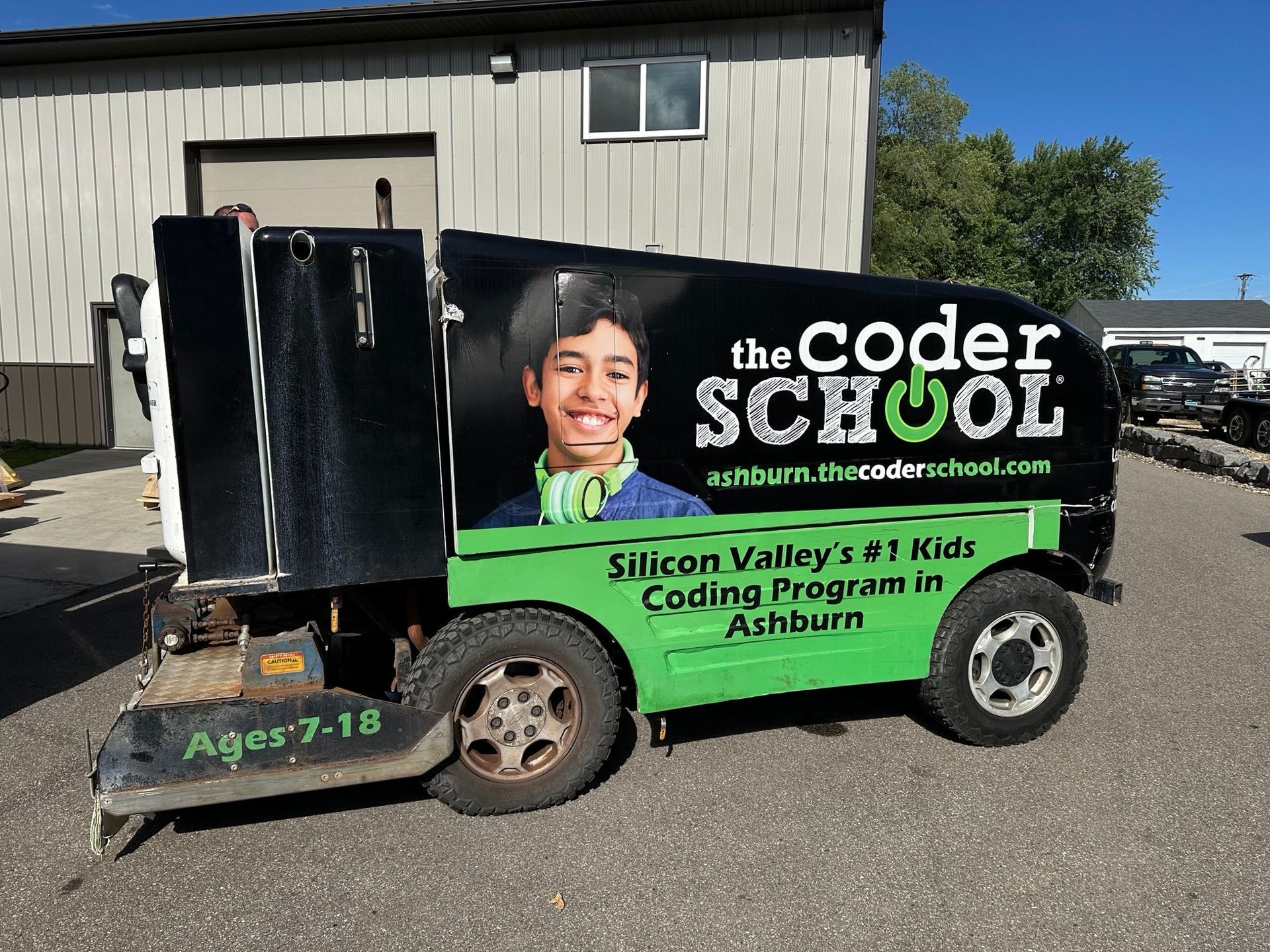 A black and green vehicle with the coder school written on it