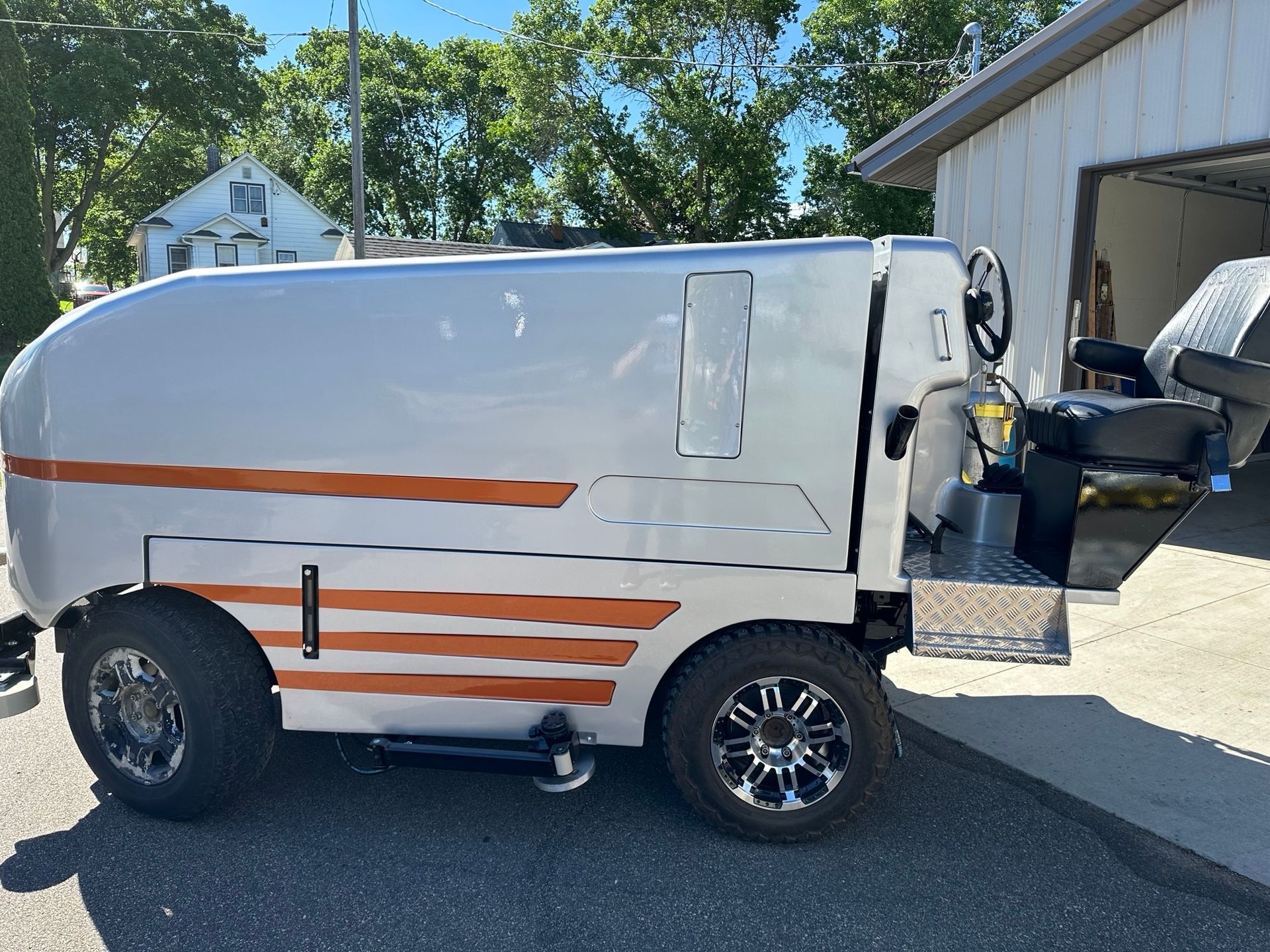 A golf cart is parked in front of a garage.