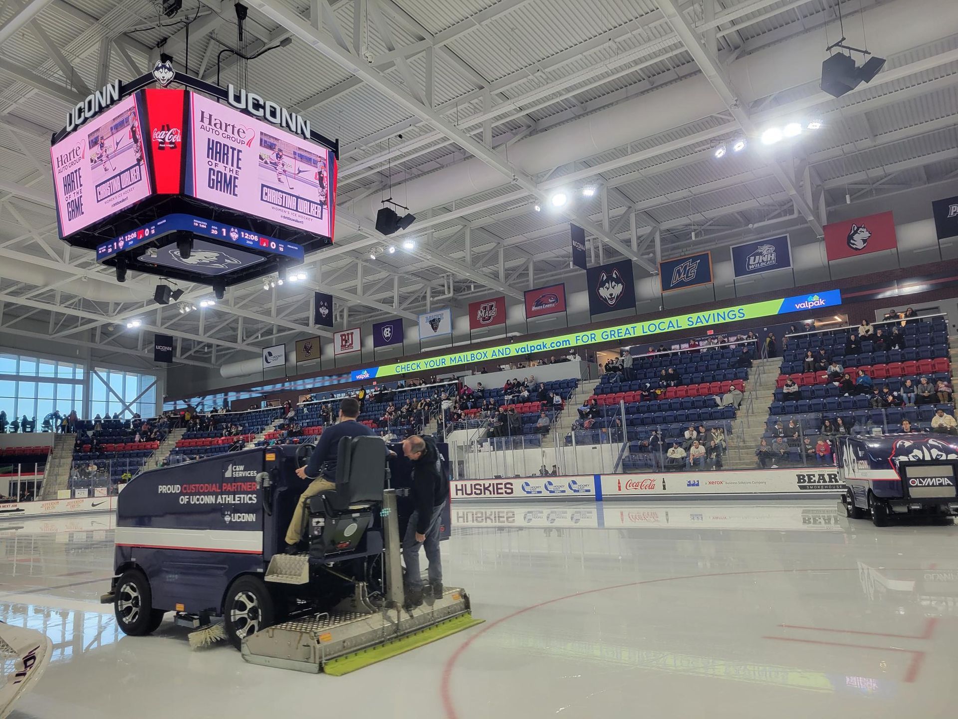 A group of people are working on a hockey rink.