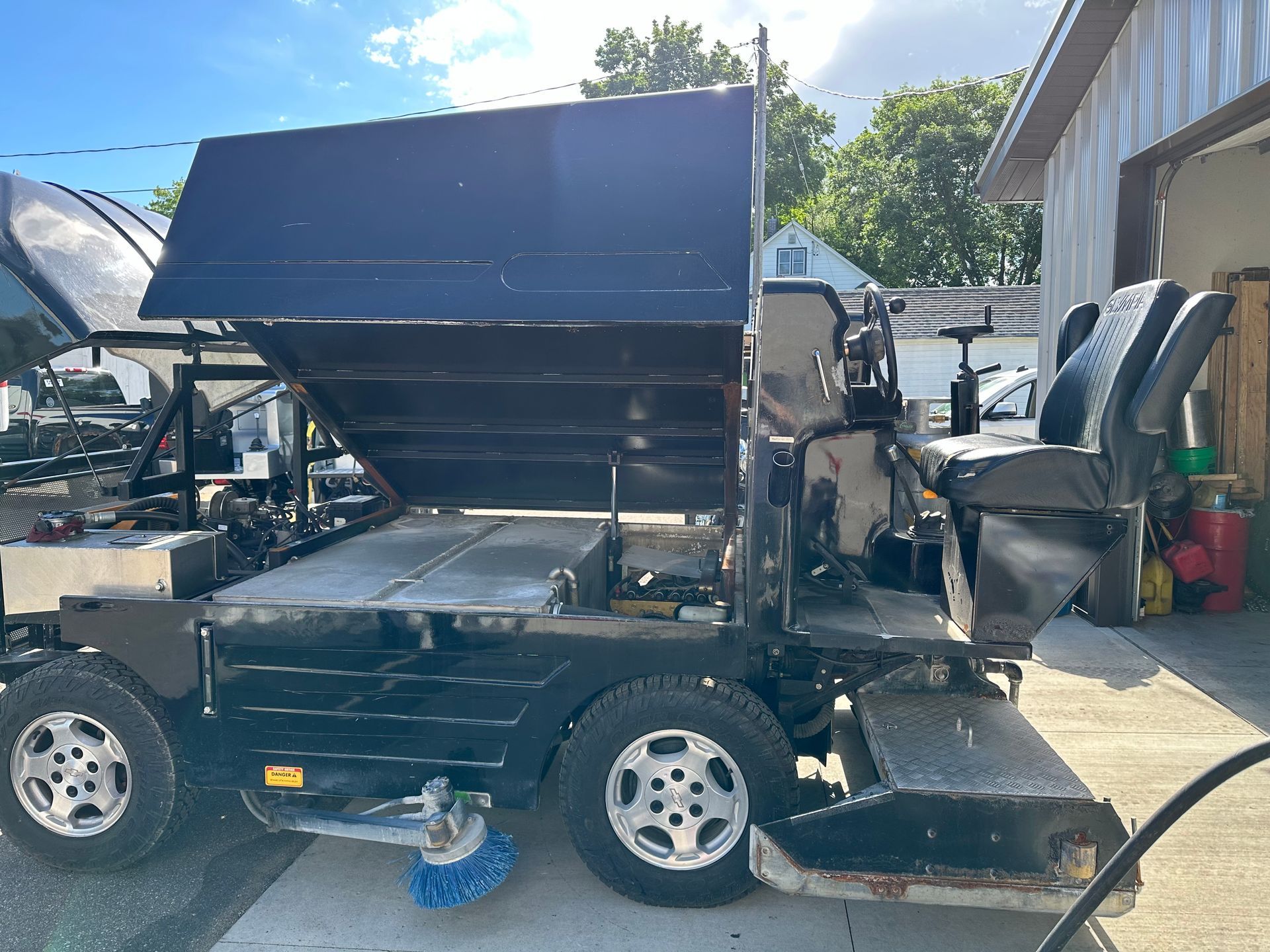 A black vehicle is parked in front of a garage.