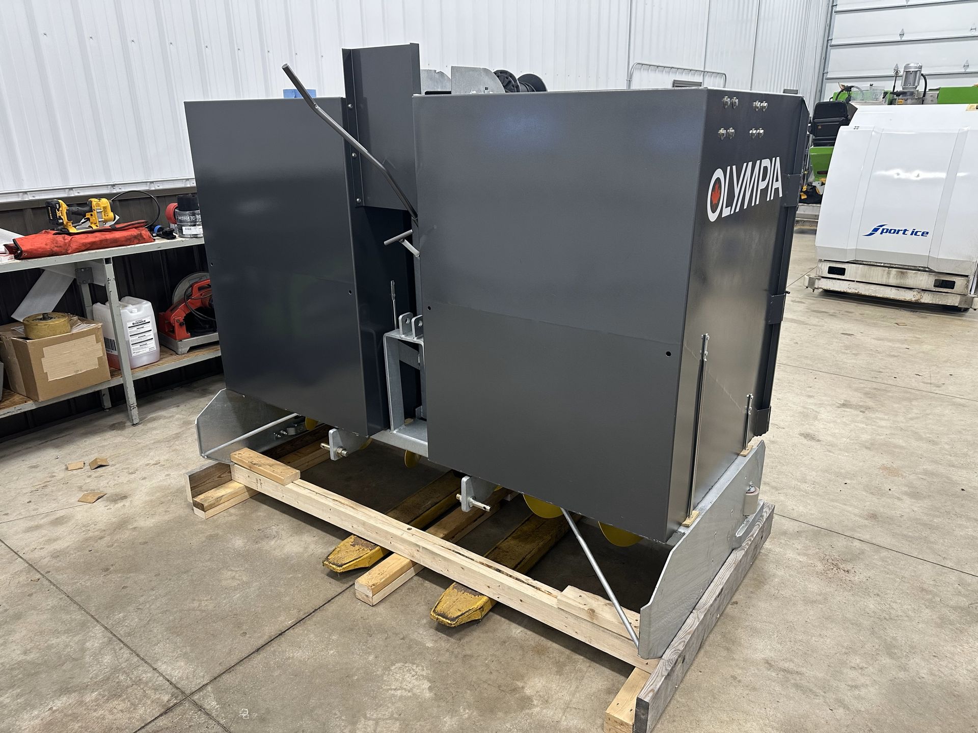 A machine is sitting on a wooden pallet in a garage.