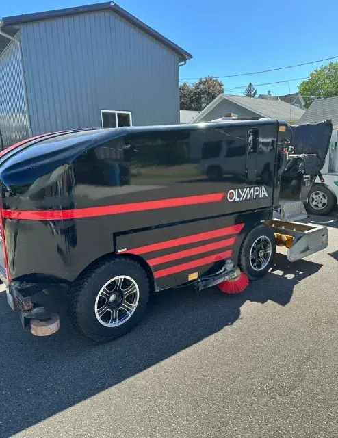 A black and red vehicle is parked in front of a building.