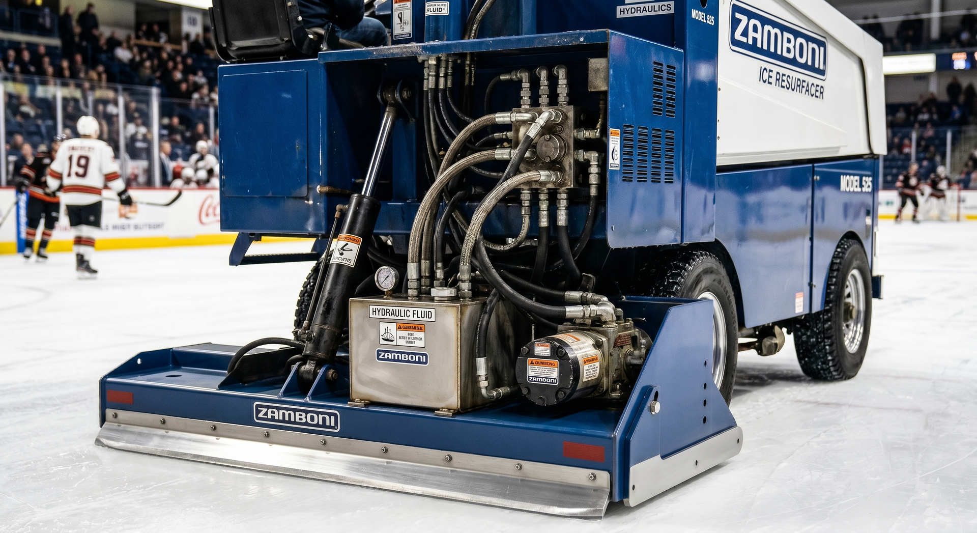 Blue Zamboni ice resurfacer on an indoor hockey rink with players in the background