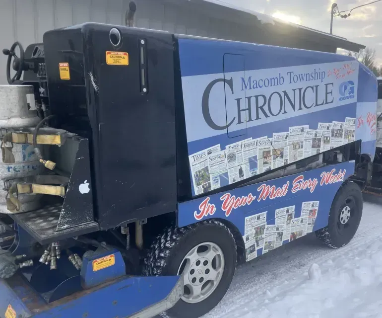 A chronicle truck is parked in the snow