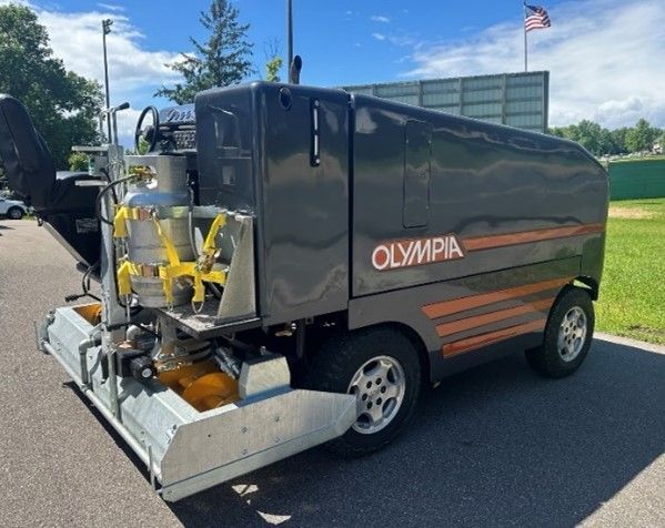 An olympia truck is parked on the side of the road