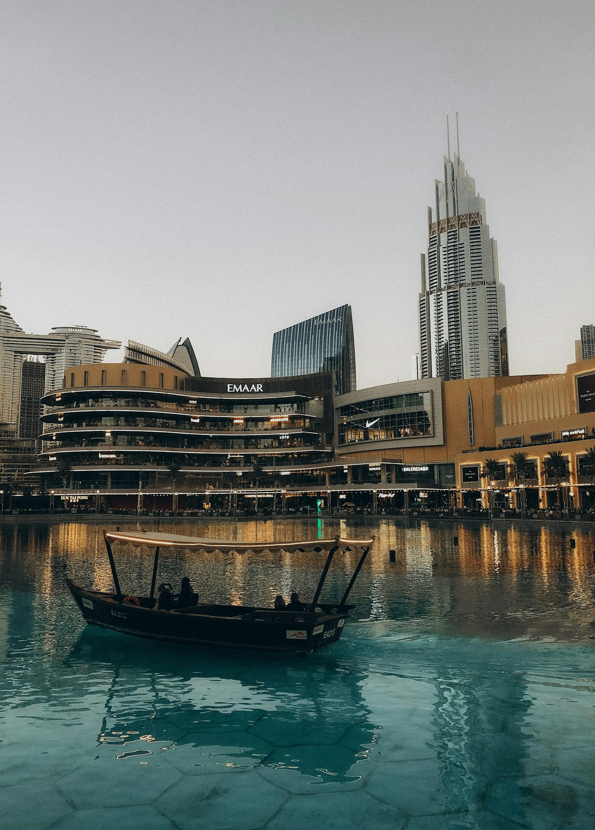 A boat is floating in the water in front of a city skyline