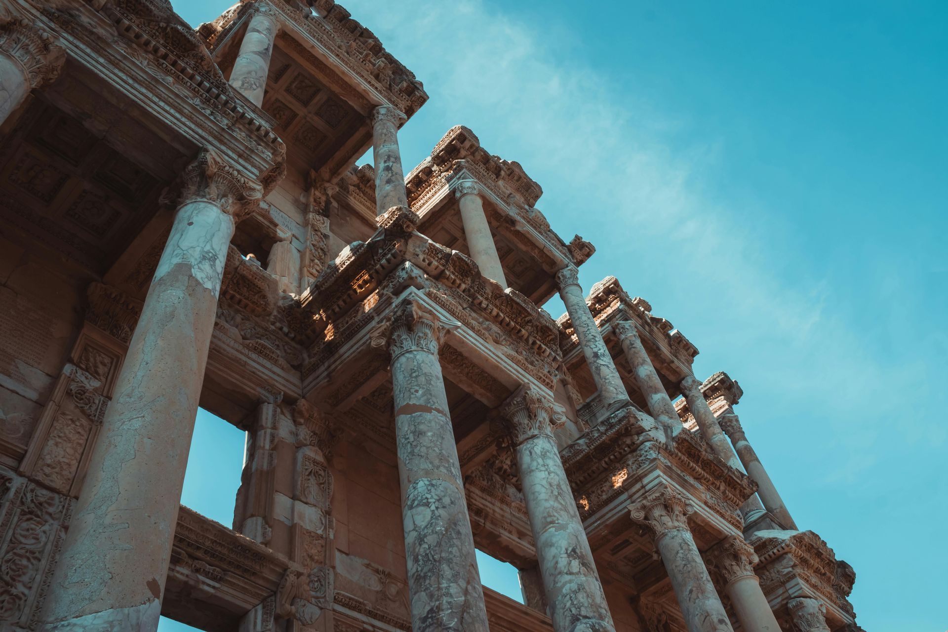 Looking up at a building with columns and a blue sky in the background.