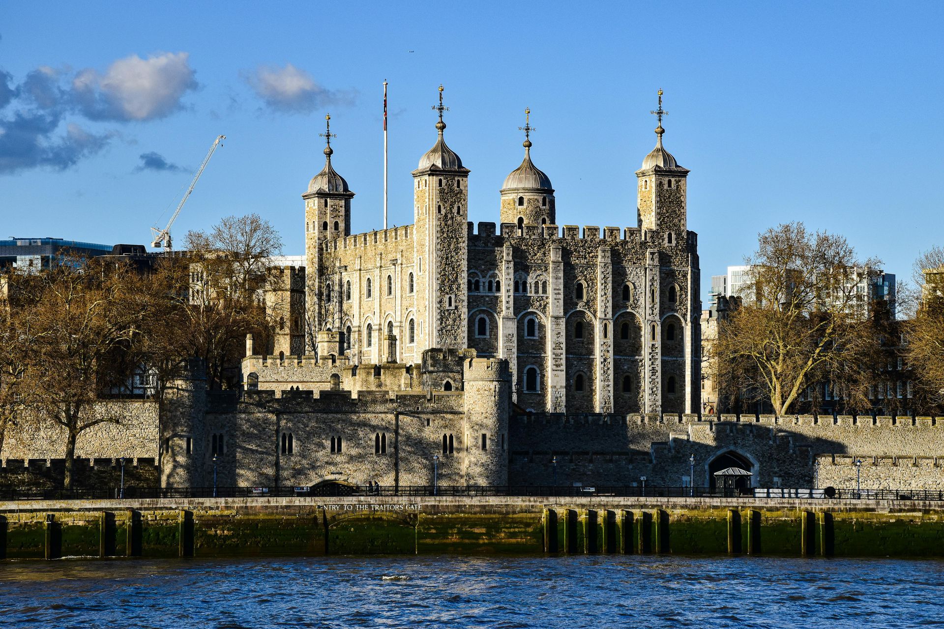 A large castle is sitting on the shore of a body of water.