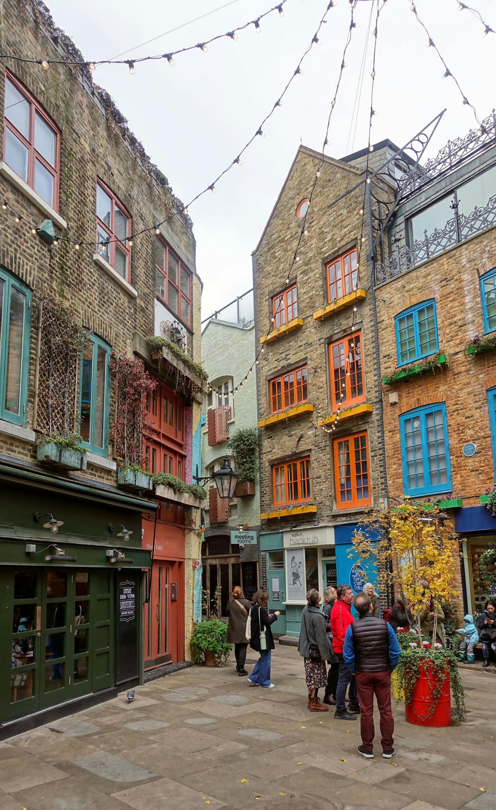 A group of people are standing in a narrow alleyway between two buildings.