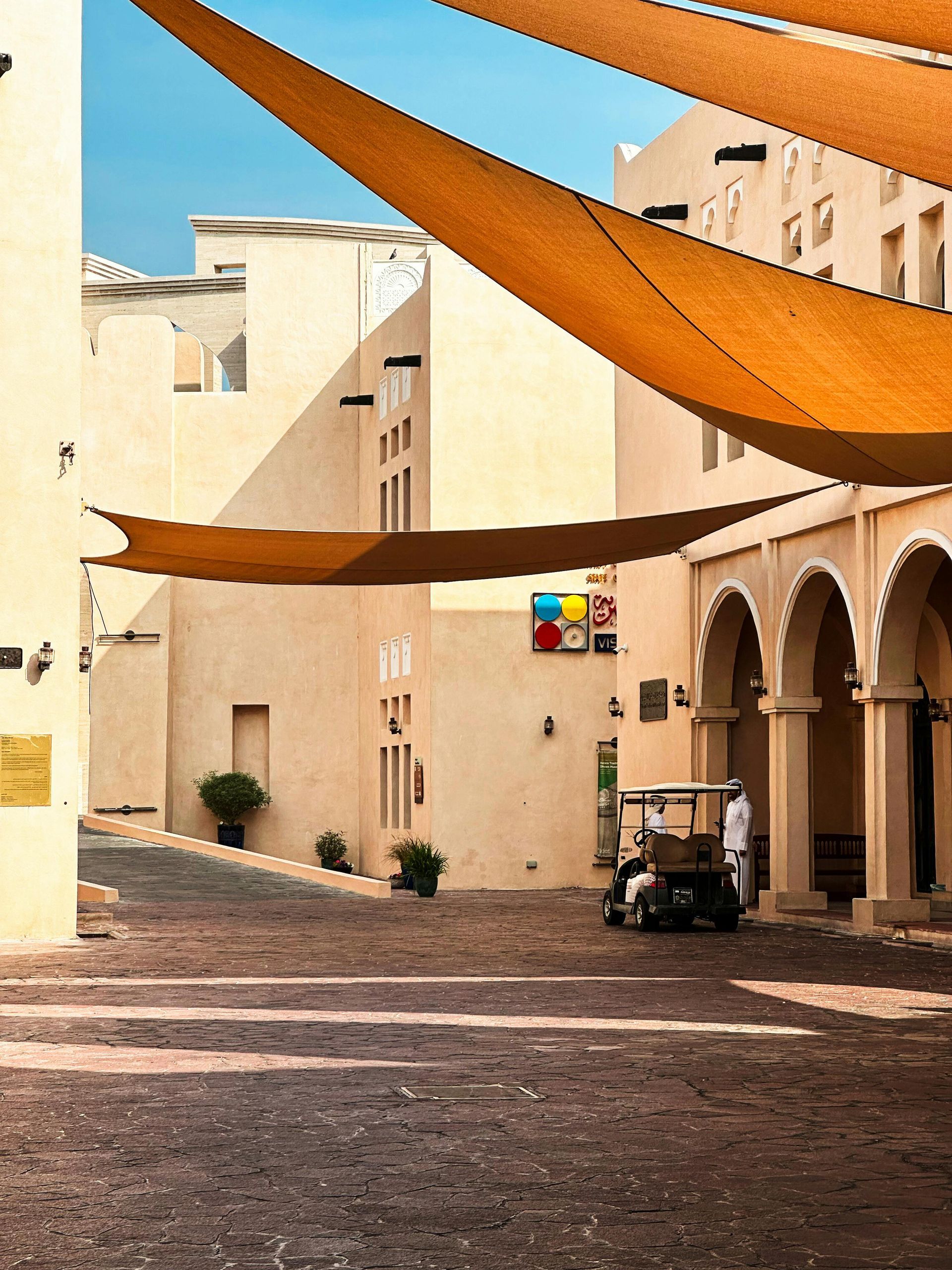 A golf cart is parked in front of a building with arches