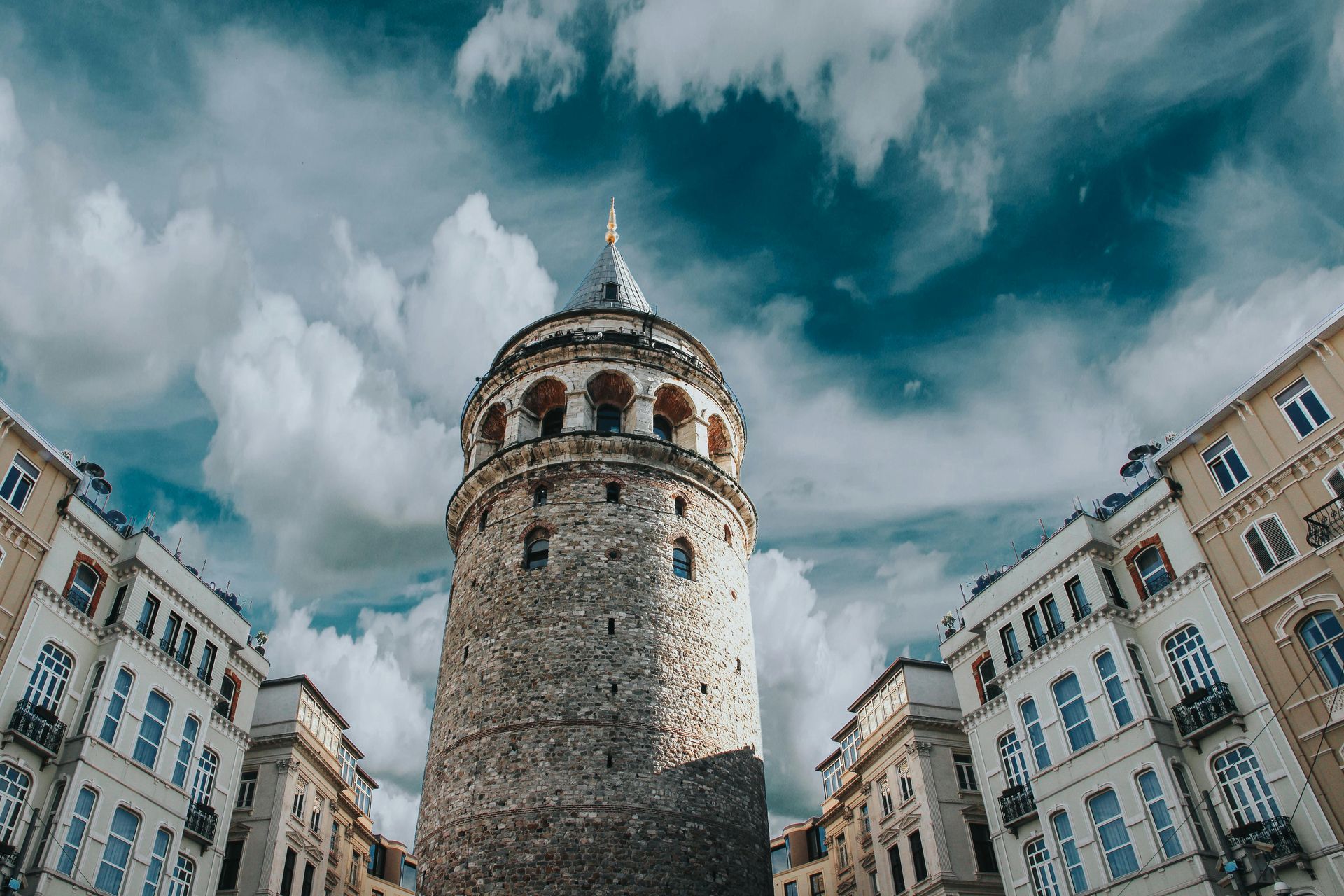 The galata tower is surrounded by tall buildings in istanbul.