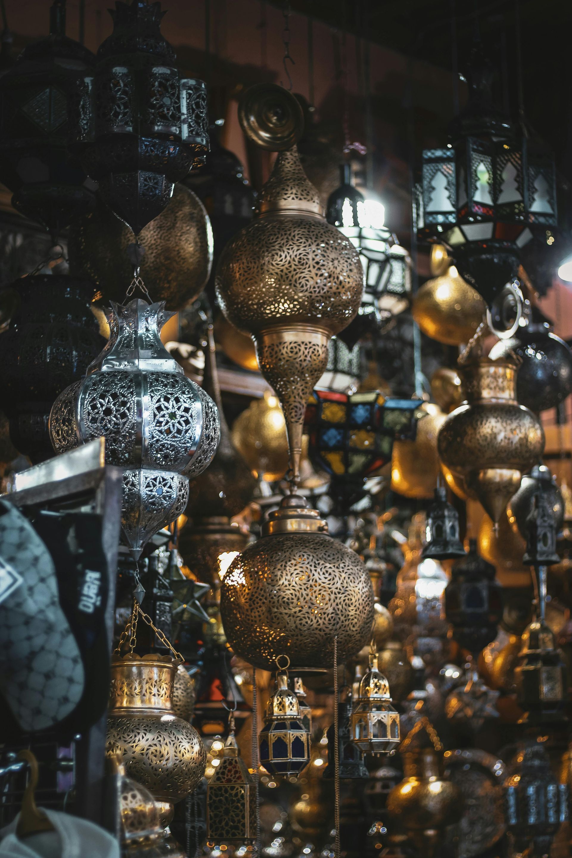 A bunch of lanterns are hanging from the ceiling in a store.