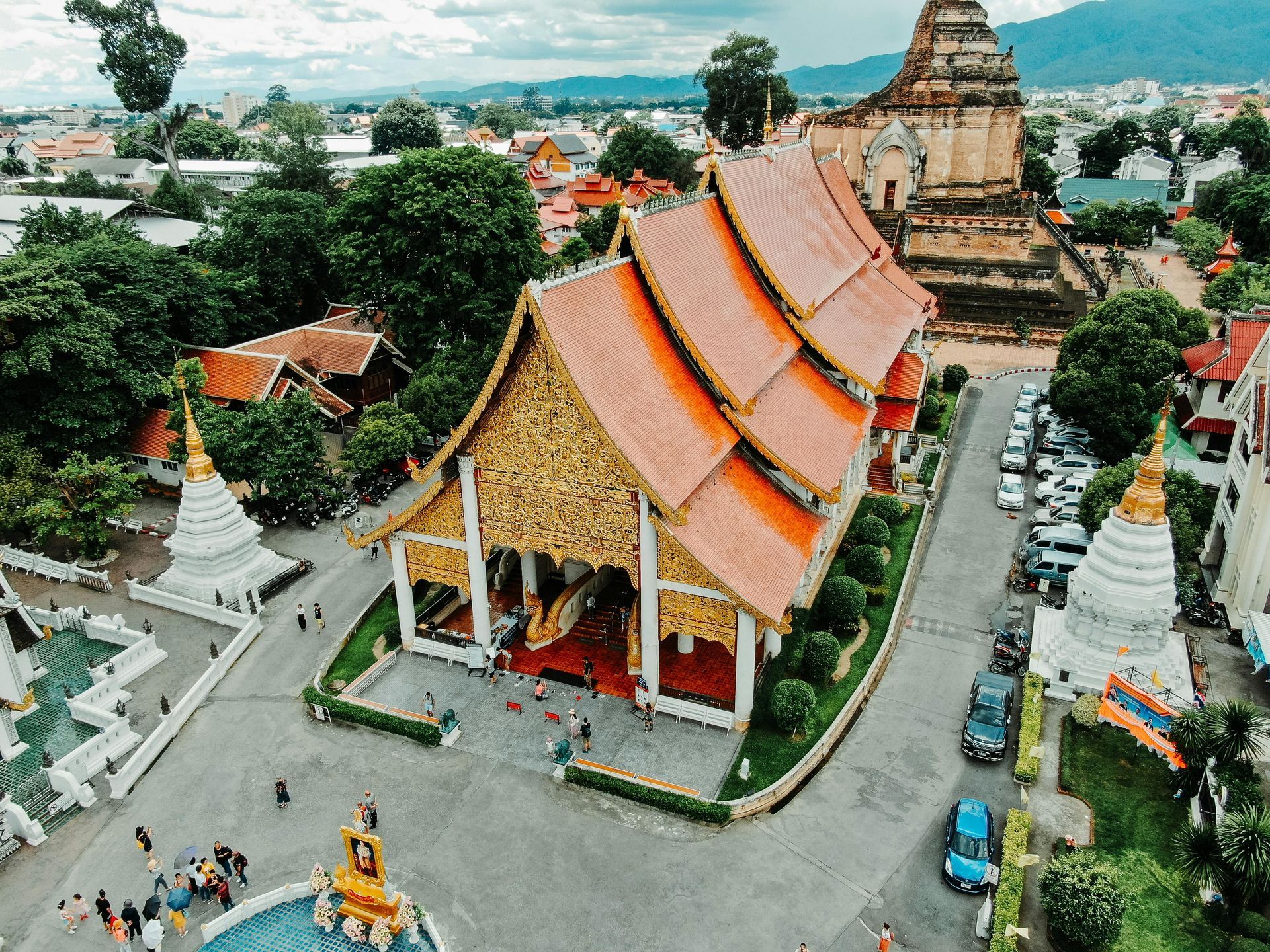 An aerial view of a temple with a red roof surrounded by trees.
