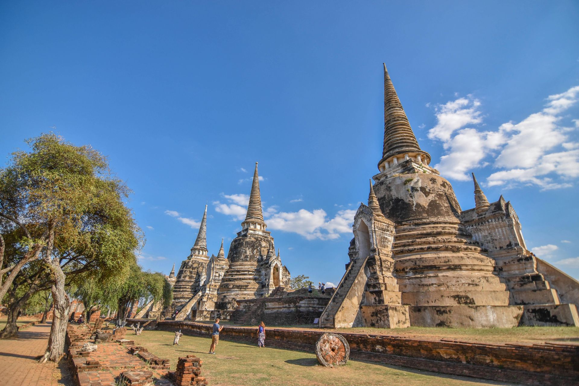 A group of people are standing in front of a row of temples.