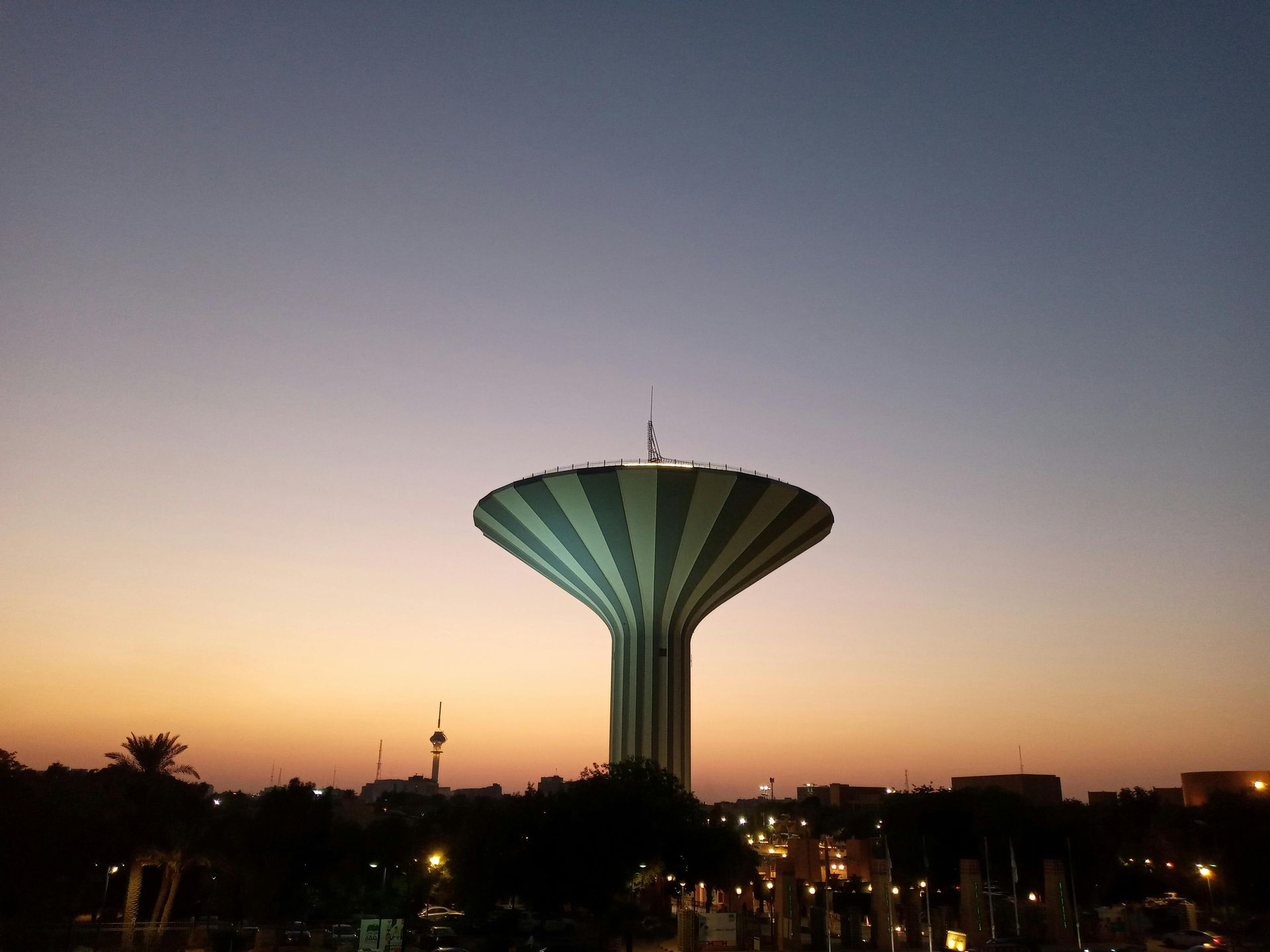 A water tower with a sunset in the background