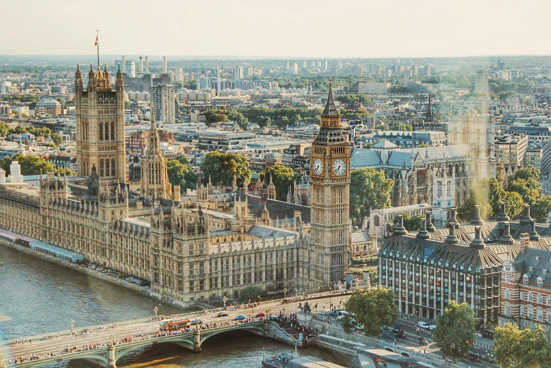 An aerial view of a city with a clock tower and a bridge over a river.