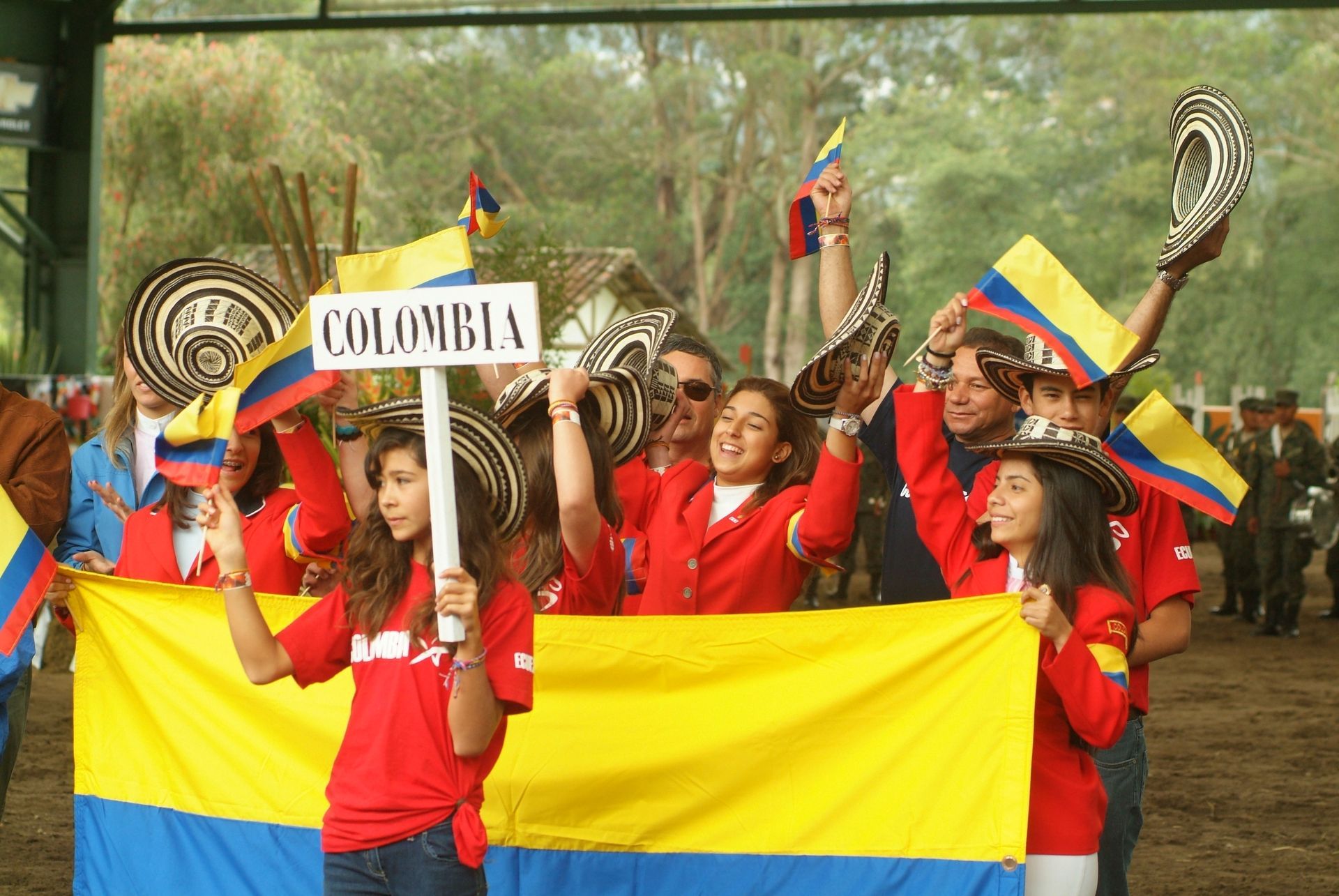 A group of people holding flags and a sign that says colombia