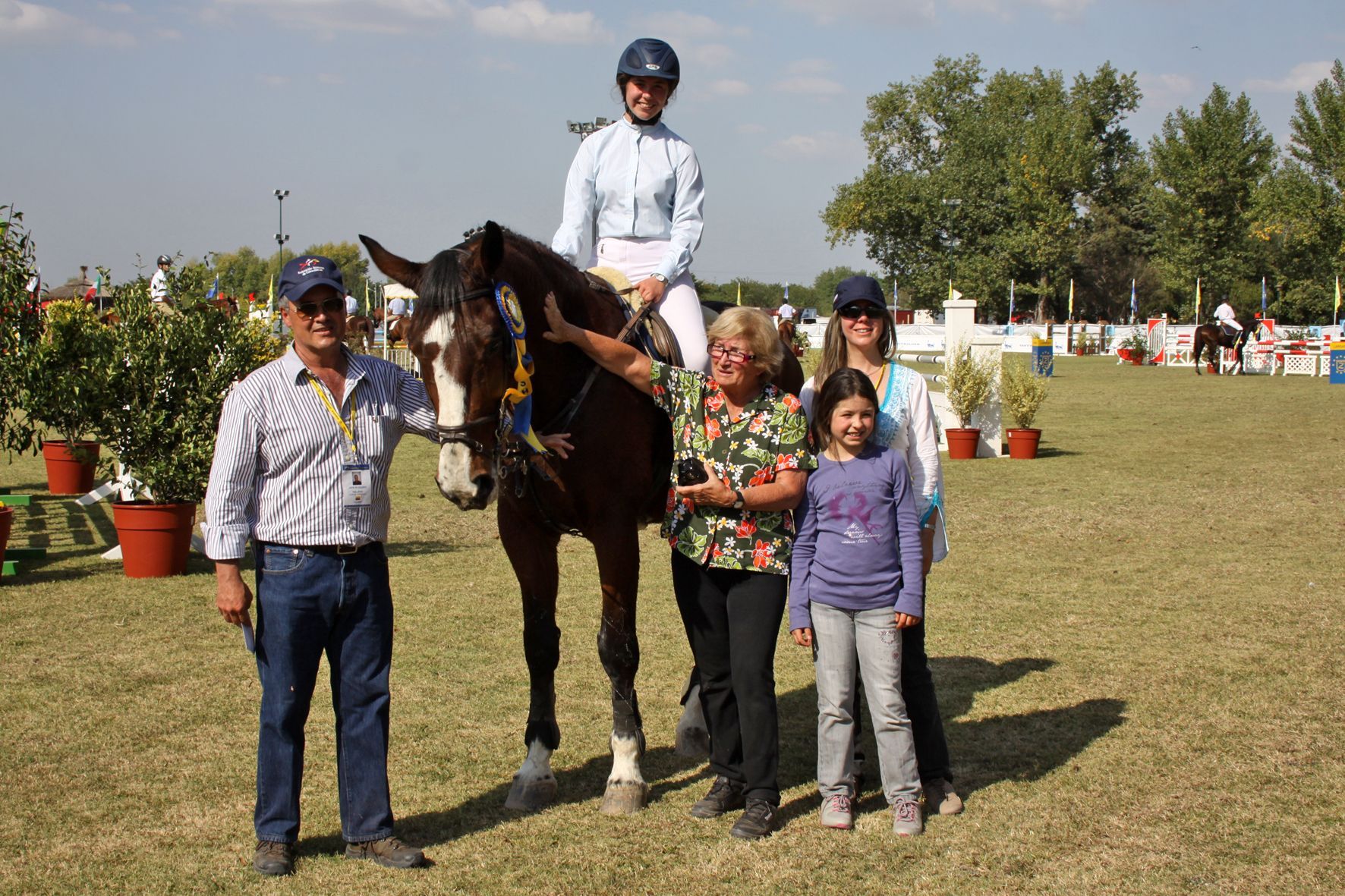 A woman riding a horse is surrounded by people