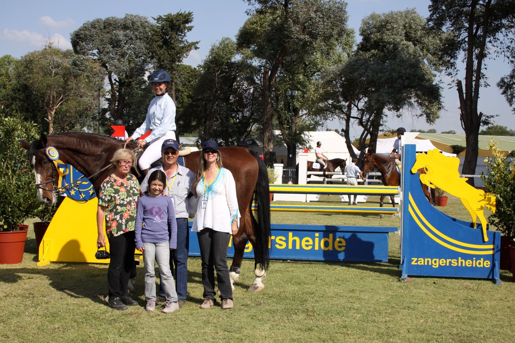 A group of people standing in front of a sign that says rheide