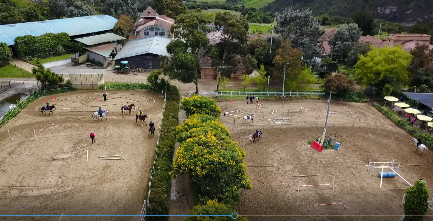 A group of people are riding horses in a dirt field.