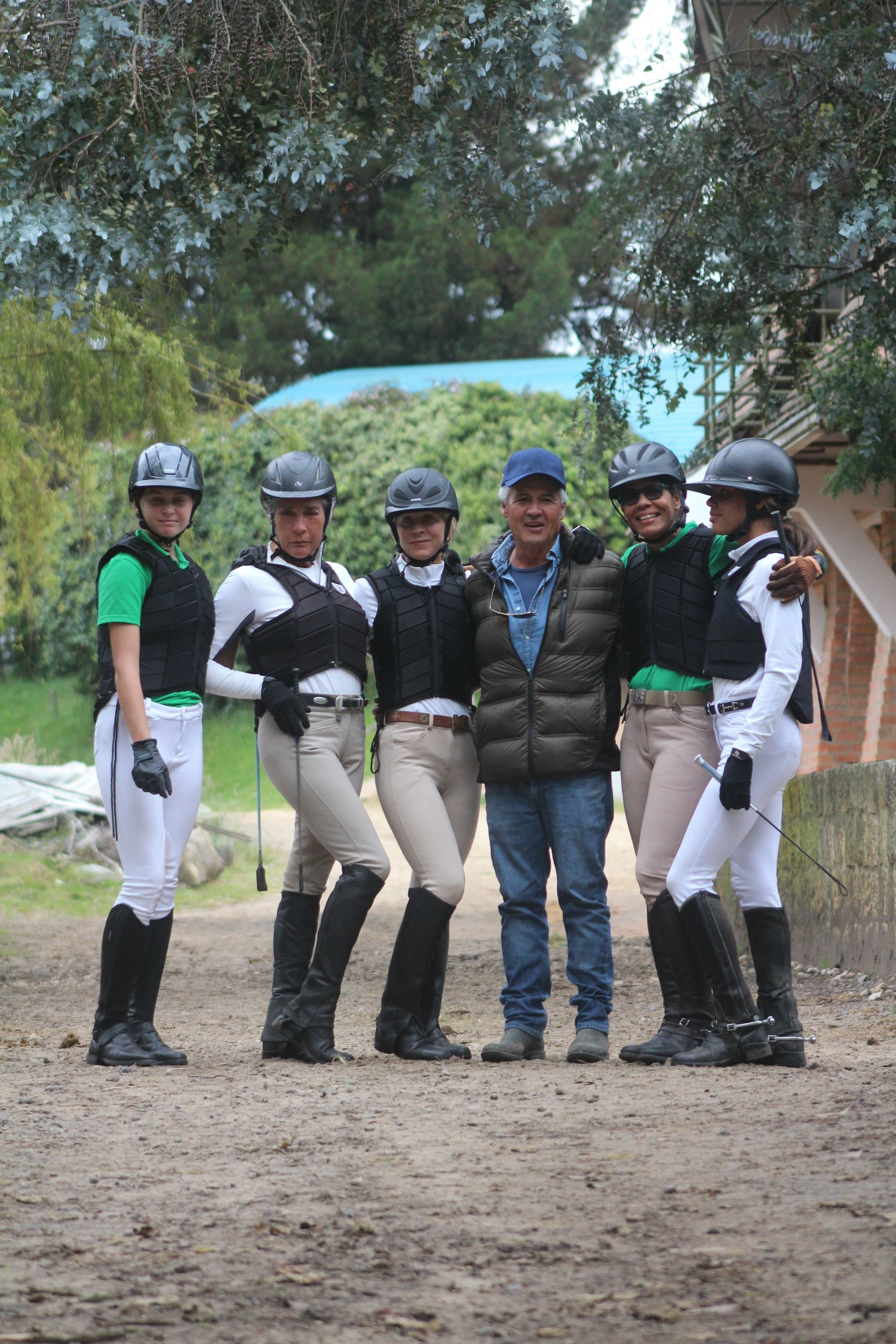 A group of horse riders posing for a picture with a man