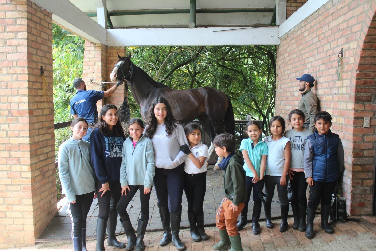 A group of children are posing for a picture with a horse.