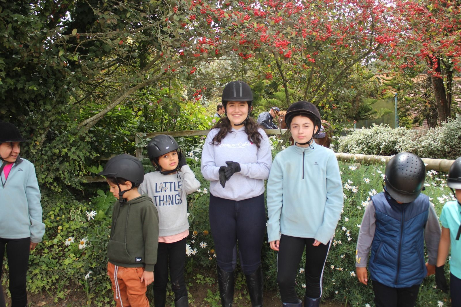 A group of children wearing helmets are standing next to each other.