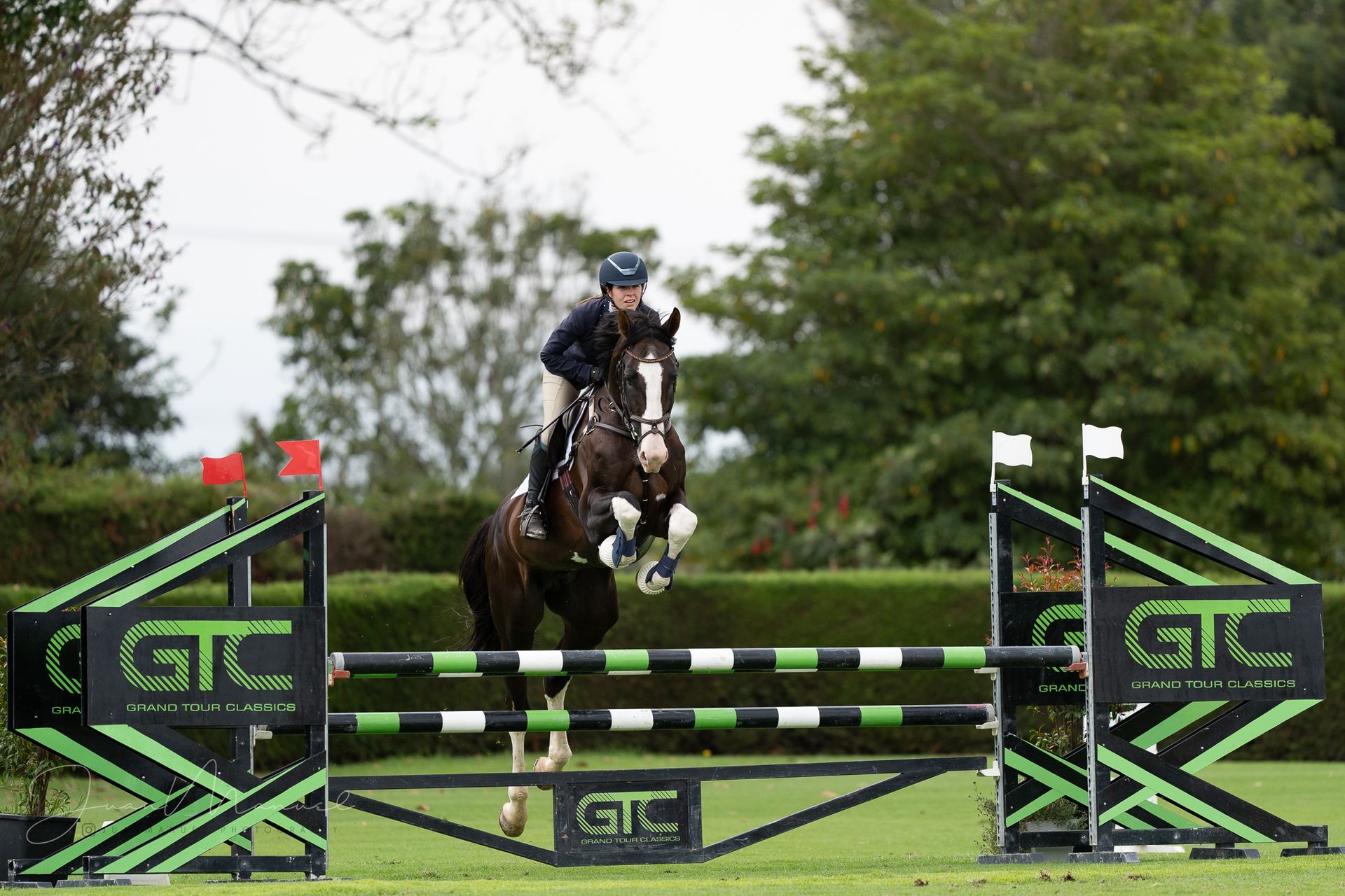 A person is riding a horse over a jump.