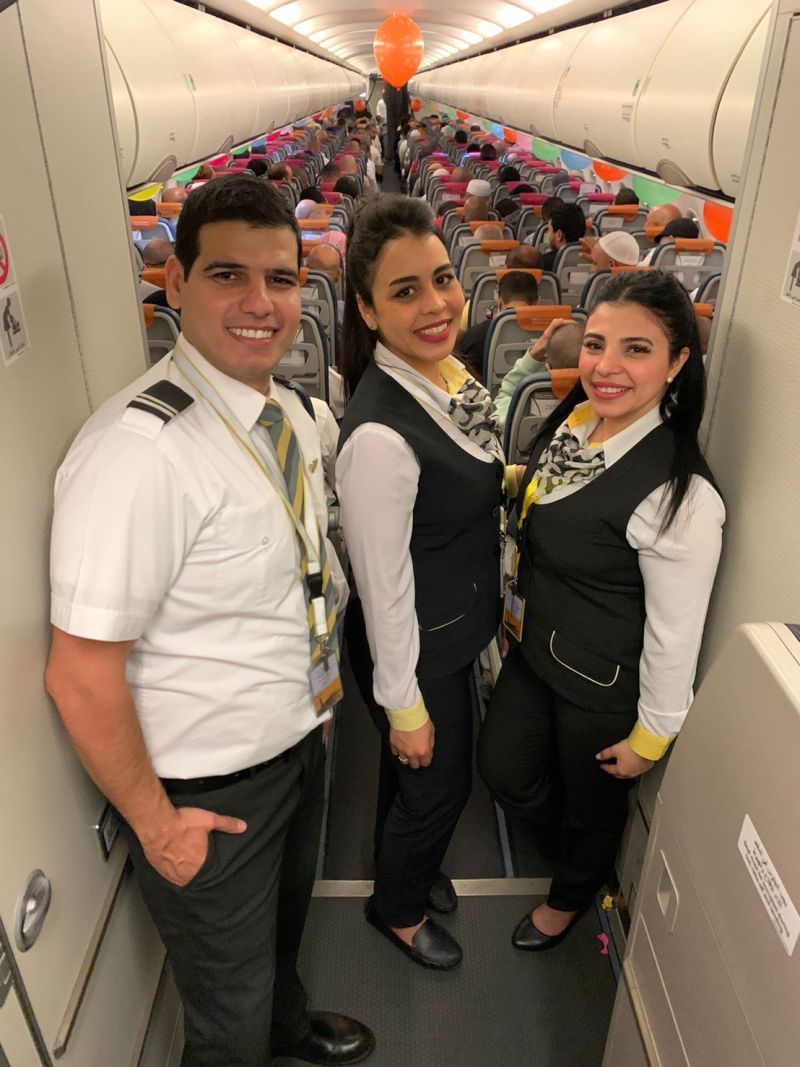 A group of people posing for a picture on a plane