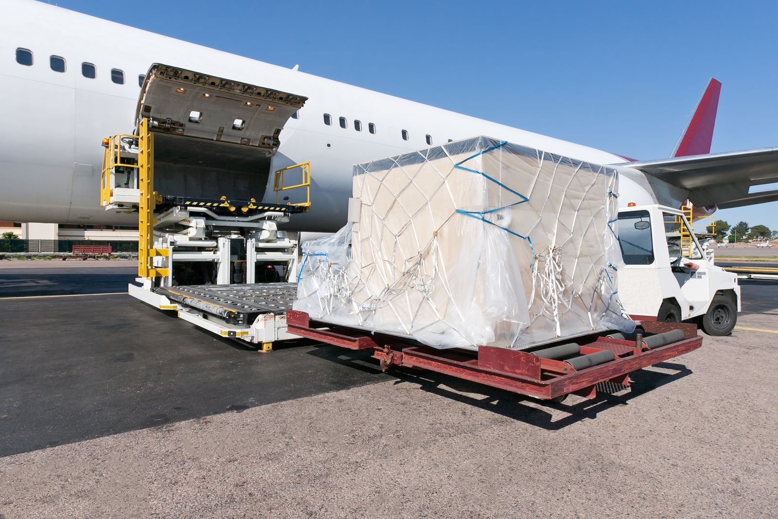 A cargo plane is being loaded with a large box