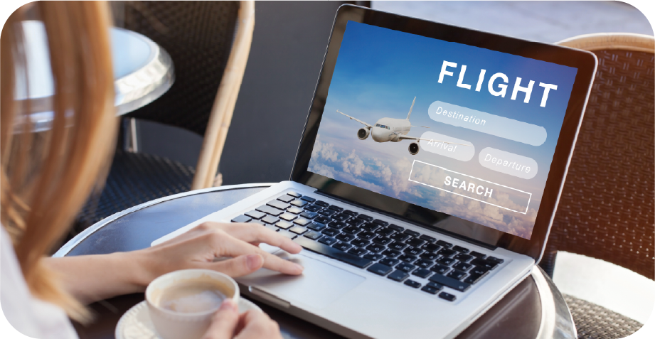 A woman is using a laptop with the word flight on the screen