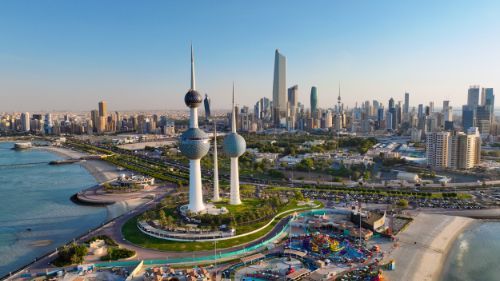 An aerial view of a city skyline with a beach in the foreground.  kuwait 