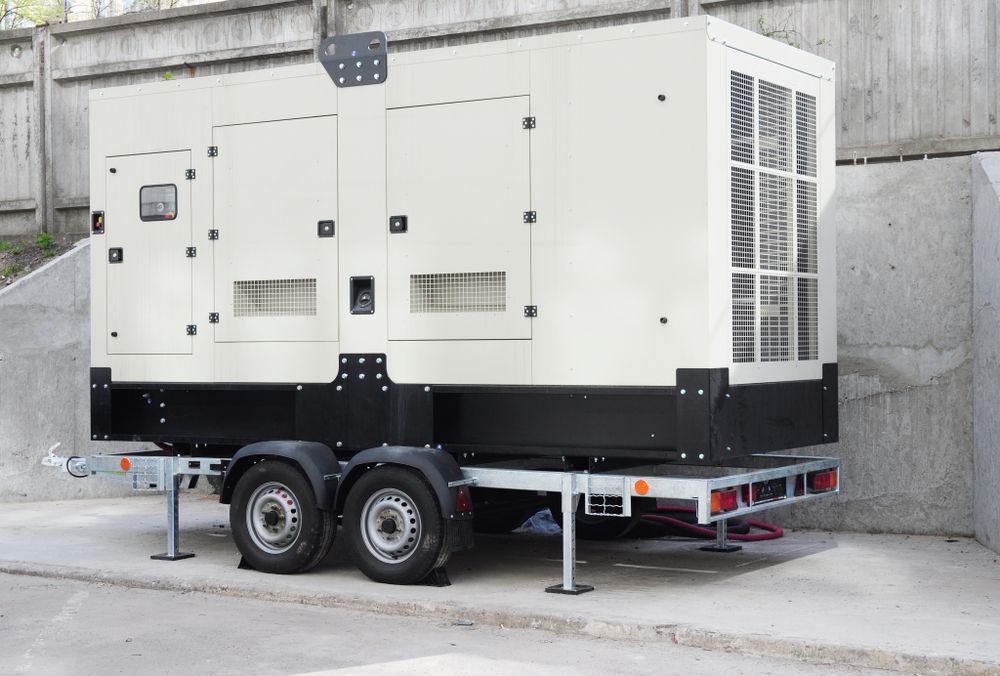 White Generator on a Trailer With Black Trim, Parked on Concrete — A.M.D. Automotive Services in Mackay, QLD