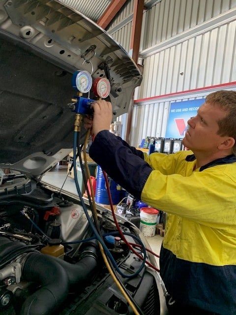Mechanic Working on Car's Air Conditioning System Using Gauges — A.M.D. Automotive Services in Mackay, QLD