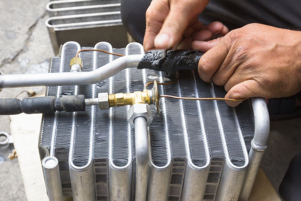 Hands Working on Car Air Conditioning Components — A.M.D. Automotive Services in Mackay, QLD
