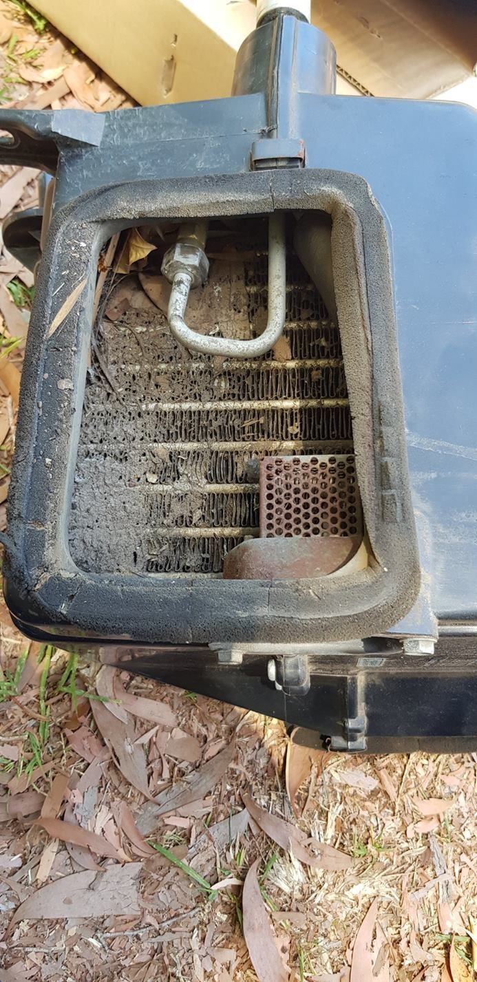 a Dirty Air Conditioning Condenser With a Bent Metal Pipe and Debris Inside — A.M.D. Automotive Services in Proserpine, QLD