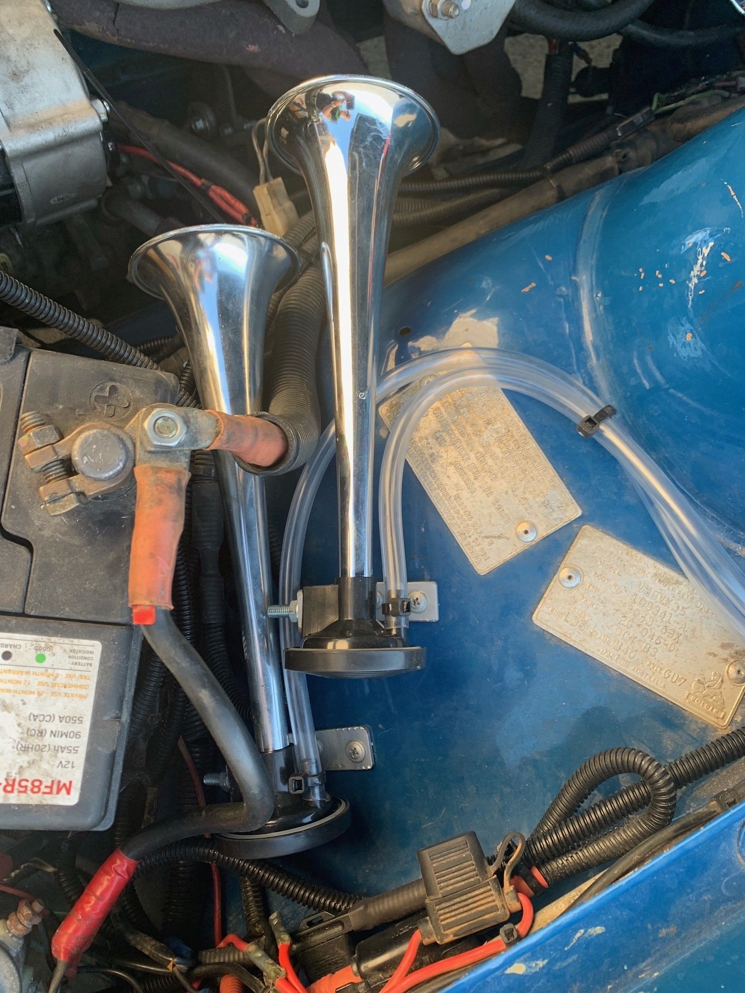 Chrome Air Horns Mounted in a Vehicle's Engine Bay Next to the Battery — A.M.D. Automotive Services in Bowen, QLD