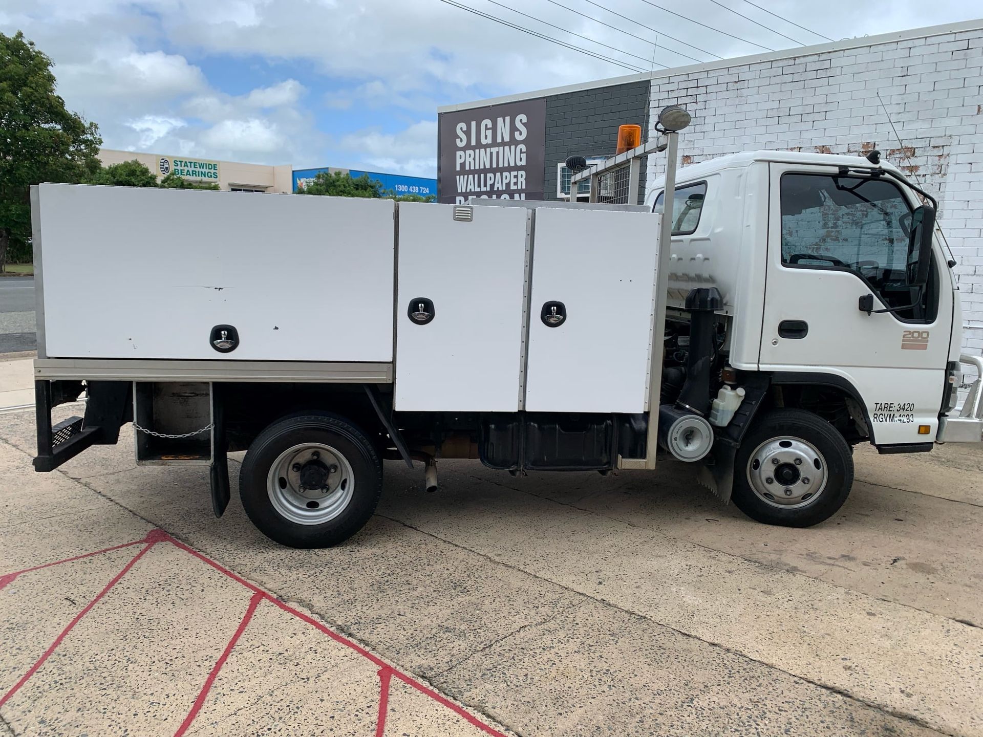 White Work Truck Parked Next to a Building — A.M.D. Automotive Services in Mackay, QLD